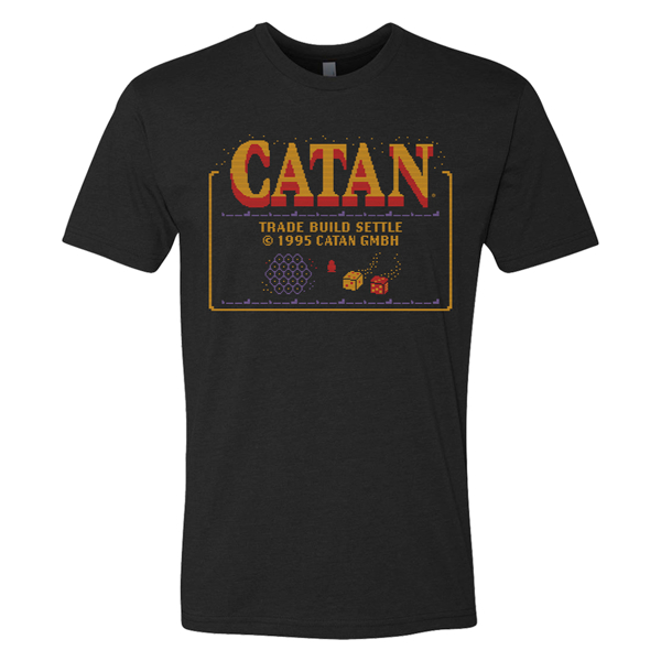 Black t-shirt with a large Catan logo on the chet area, written "Trade, Build, Settle" under it in yellow