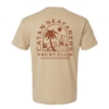 Back view of tan CATAN Seafarers Yacht Club t-shirt featuring a large island scene with palm tree, sailboat, sun, and Yacht Club text