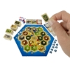 Person holding card with World's Smallest CATAN Game set up